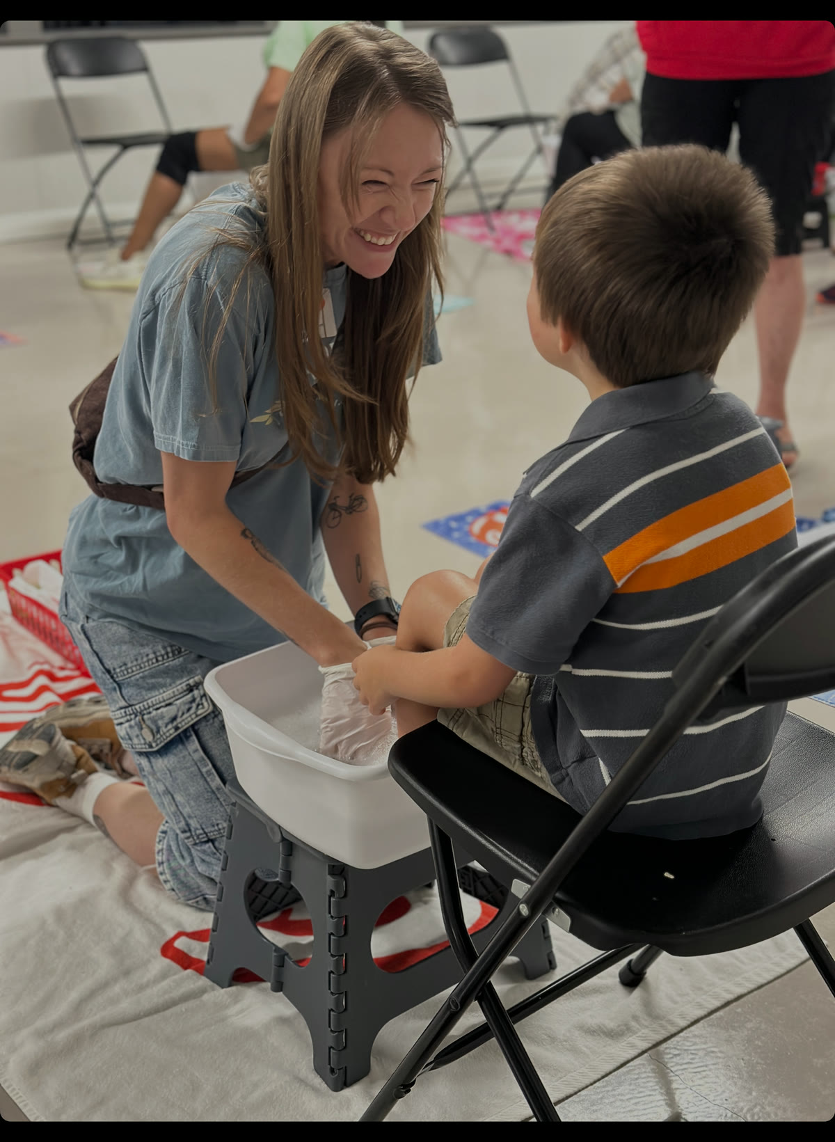 A volunteer helps a child with new shoes at a Shoes of Hope event.